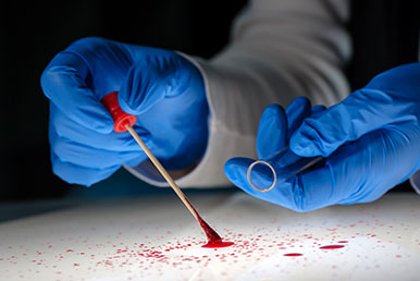 Kriminaltechniker sichert Blutproben zur DNA-Analyse